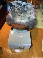 Glass aquarium with accessories inside placed on table, original box in foreground