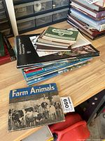 Stack of wildlife books and Canadian Geographic magazines on workbench