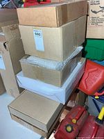 Stack of sealed cardboard boxes containing exit signs
