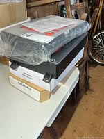 Two exit signs stacked, one wrapped, one unwrapped, box labels visible