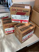 All three sealed Lightolier LyteCaster boxes on table