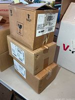 Three cardboard boxes of Stonco fixtures stacked