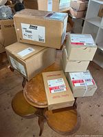 Stack of nine sealed lighting boxes including Lightolier, Stonco and unmarked boxes