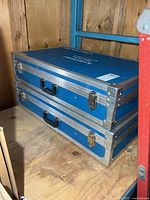 Two stacked blue aluminum Lightolier Lytecaster display cases