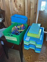 Overall lot showing green tote with scissors and stack of letter trays