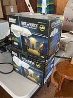 Two sealed boxes of Stonco NyteWatch motion sensor lights on table