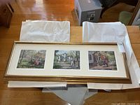 wide view of framed set showing three prints in gold frame