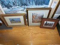 Three framed prints leaning against wall