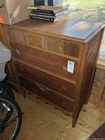 Front view of wooden highboy dresser with four drawers