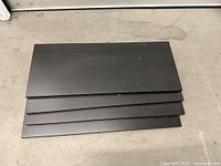 Top view of four stacked dark wood shelves