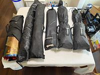 Five black fabric sleeves containing softboxes and one transparent gel roll