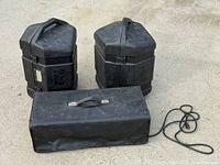 Two interlocked hexagonal monitor cases and rectangular case with power cord