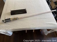 Full view of lightsaber on table with wall mount