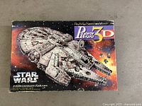 Front of Puzz3D Millennium Falcon puzzle box showing branding and artwork