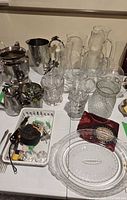 Overview of hammered metal set and multiple clear glass vases on table