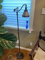 Full view of floor bridge lamp and cobalt blue vase