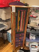 Front view of tall painted cabinet showing door and drawers