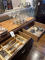 Overview of glassware, coasters, book and drawers of cutlery