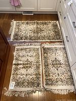 All three silk rugs laid out on floor showing overall design and size comparison