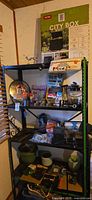 Shelf unit with assorted items including Keter City Box packaging, planter pots, tools and hardware
