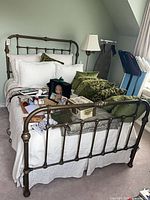 Full view of bed with metal headboard, footboard, bedding, adjustable base beneath