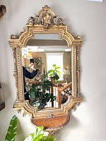 Full view of mirror showing ornate frame and attached shelf