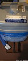 Grey and blue SnowJoe canister vacuum lid with hose