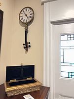 Clock on wall above gilded box