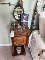 Nightstand beside bed with accessories on top and shelf