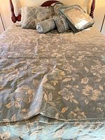 Queen bed with floral bedding set and pillows