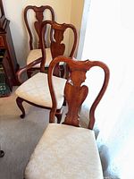 Two cherry side chairs with cream upholstered seats
