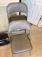 Front view of stacked padded folding chairs