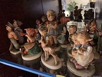 Shelf view showing multiple Hummel figurines of children and animals