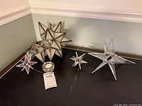 Five glass Moravian stars and tealight holder on tabletop