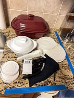 All items laid out on counter showing baker, lids, bowls, wine set