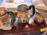 Front view of three Royal Doulton character jugs Neptune, St George, The Poacher