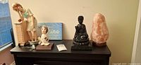 Group showing salt lamp, Buddha statue, two nurse figurines