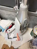 Steam mop standing upright with pads and cord visible
