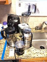 All five appliances on countertop including blender jar, air fryer, kettle, burr grinder, blade grinder