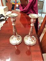 Pair of sterling candle holders on table top