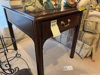 Full view of Thomasville cherry end table showing single drawer and brass pull