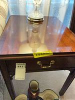 Front view of end table showing drawer and brass pull