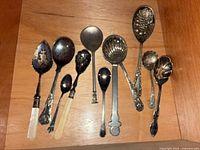 All eleven spoons laid on wood surface