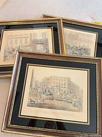 Three framed carriage scene prints stacked, showing frames and mats