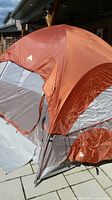 Angled side view of erected orange and gray Ozark Trail dome tent