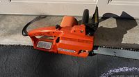 Left side view of orange Craftsman electric chainsaw