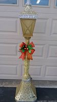 Full view of gold glitter lighted Christmas lamppost