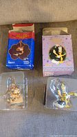 Both ornaments in plastic inserts with their corresponding Aladdin and Beauty and the Beast boxes