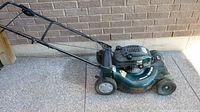 Side profile showing full mower, handle, wheels, deck