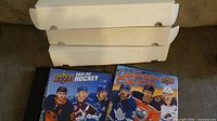 Three white cardboard card storage boxes stacked, two Upper Deck binders visible